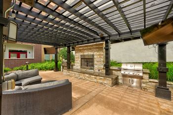a pergola with a fireplace and a grill